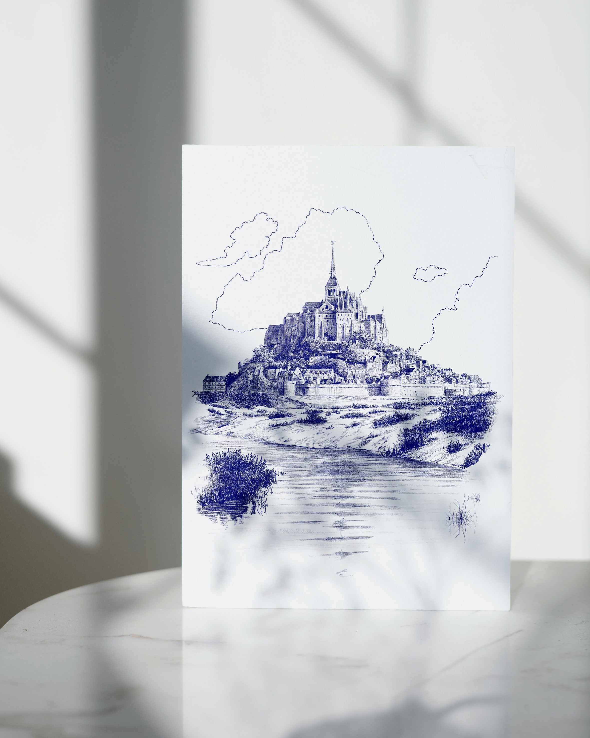dessin bleu d'une vue du Mont-Saint-Michel sur fond blanc neutre